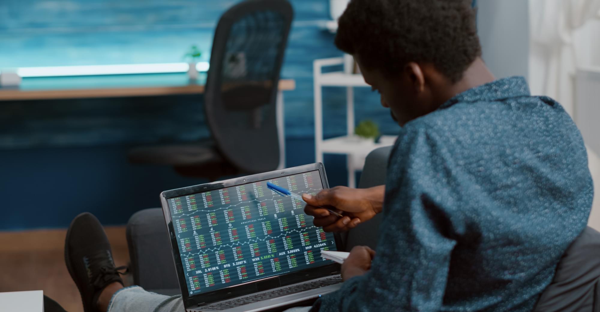 A man looking comparing numbers on a computer