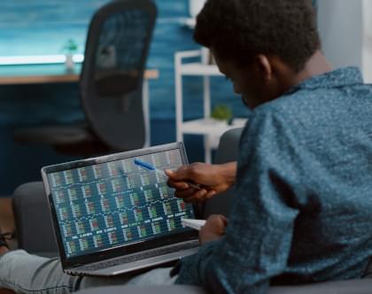 A man comparing numbers on a computer