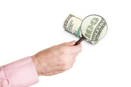 A $100 bill under a magnifying glass